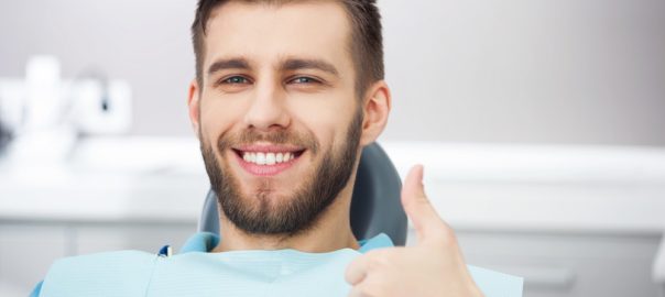 Portrait Of Happy Patient In Dental Chair.