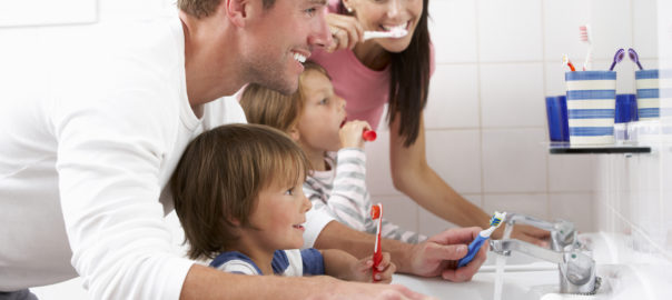 Family In Bathroom Brushing Teeth Together