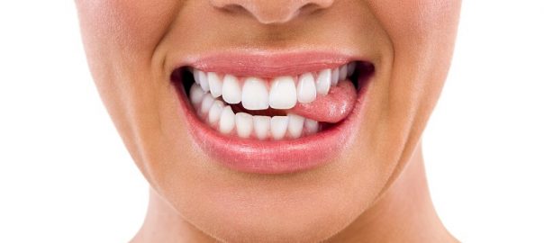 Closeup of woman's mouth, smiling, biting tooth