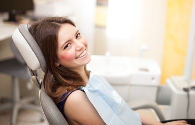 Patient Smiling in Dental Chair Side Angle