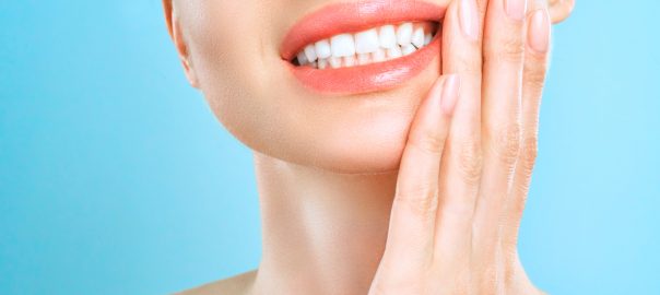 Woman holding hand to face for sore gums
